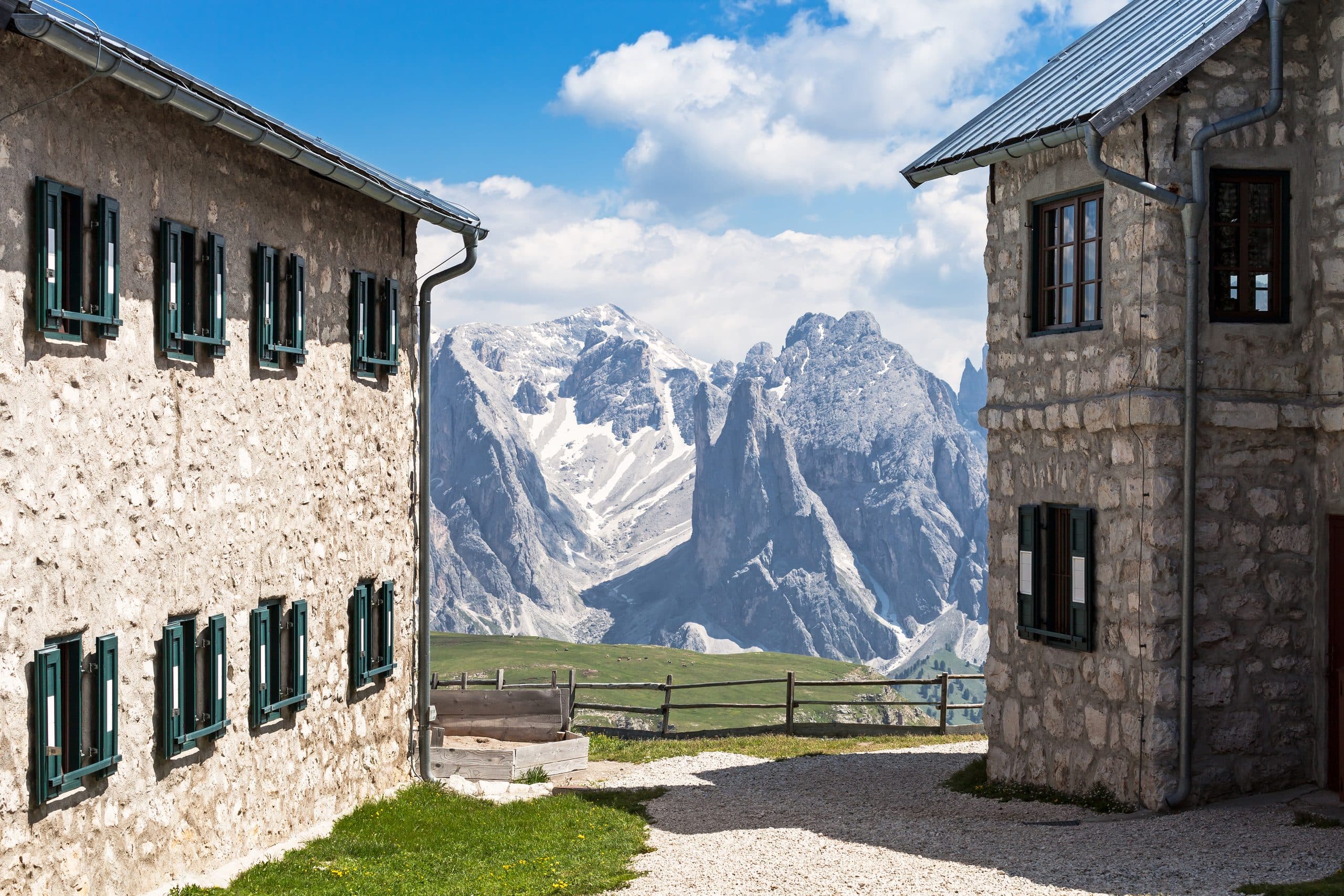 Steinhäuser vor der Rosengartengruppe, Immobilienregion Südtirol und Dolomiten