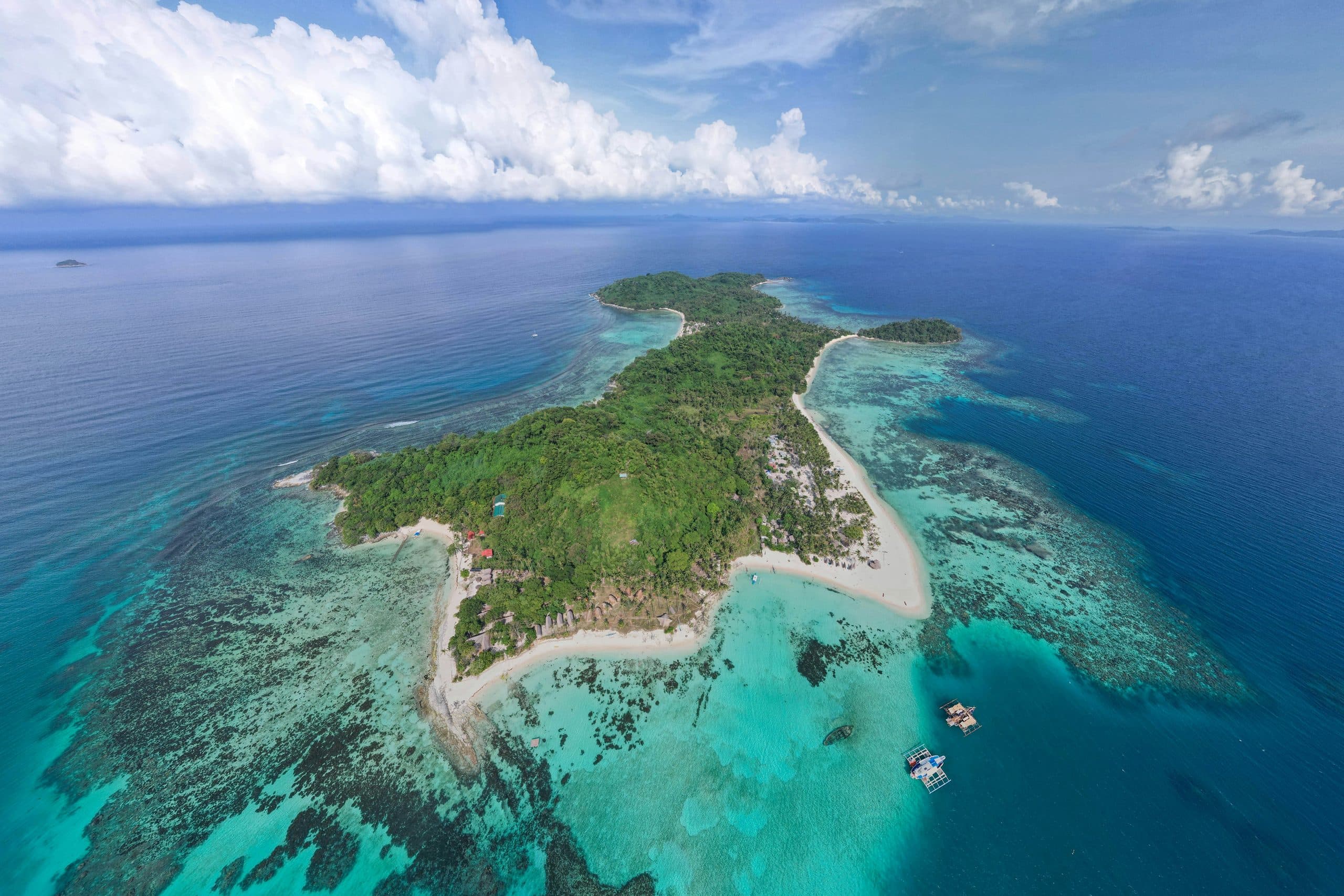 Veduta aerea di un'isola tropicale con spiagge di sabbia bianca e barriere coralline nel mare turchese