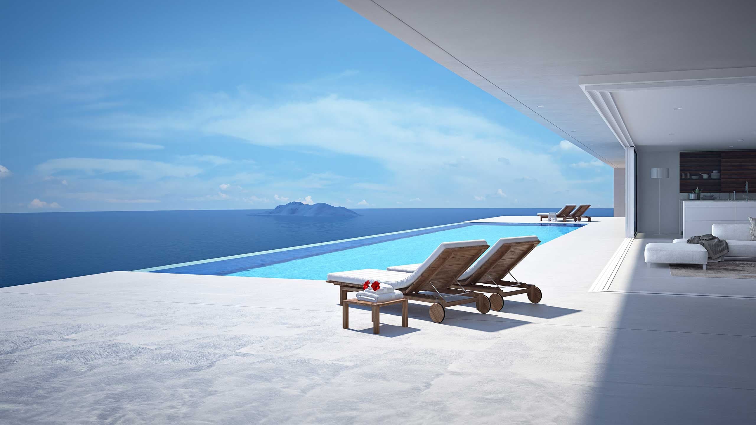 Infinity pool of a modern villa with loungers and a wide view over the open sea